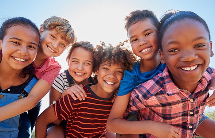 Racially diverse group of boys and girls smiling for picture