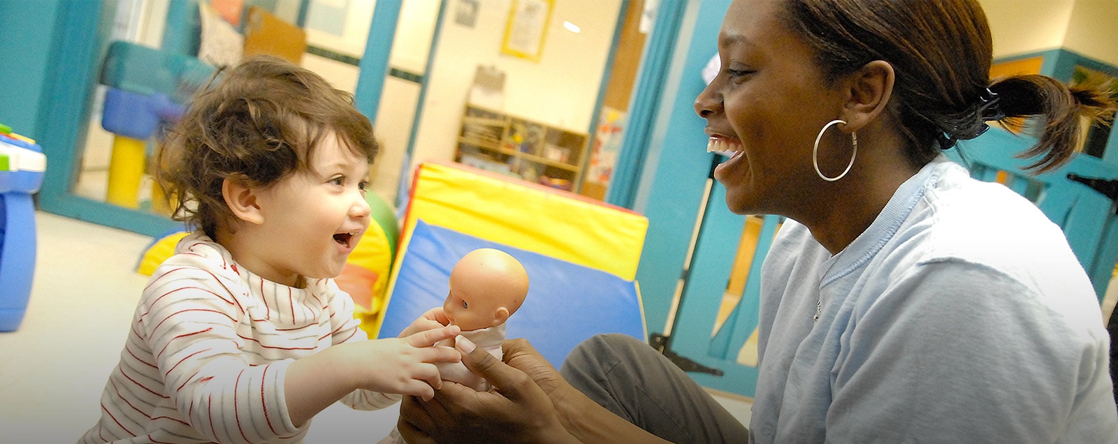 An child shares her doll with an early education provider.