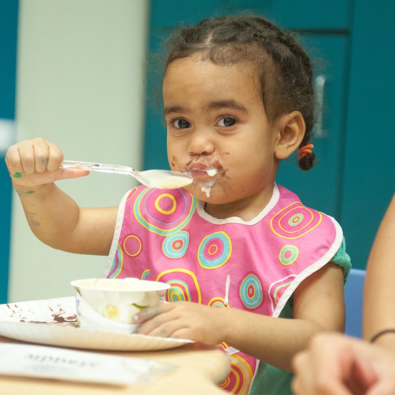 A child eats with a spoon.