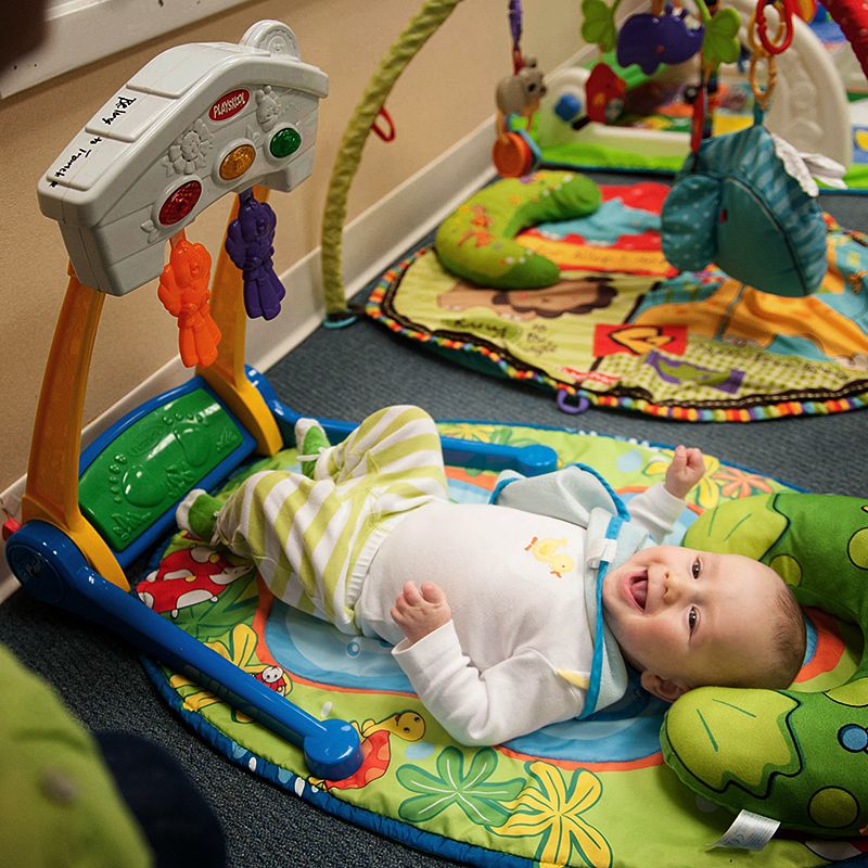 Un bebé juega con sus juguetes mientras está acostado
