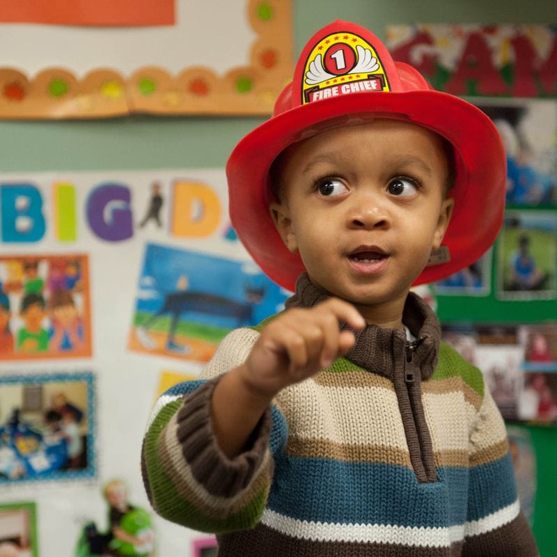 Niño con un casco de bombero.