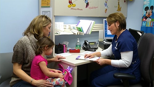 Doctor reviewing a milestone checklist with a parent