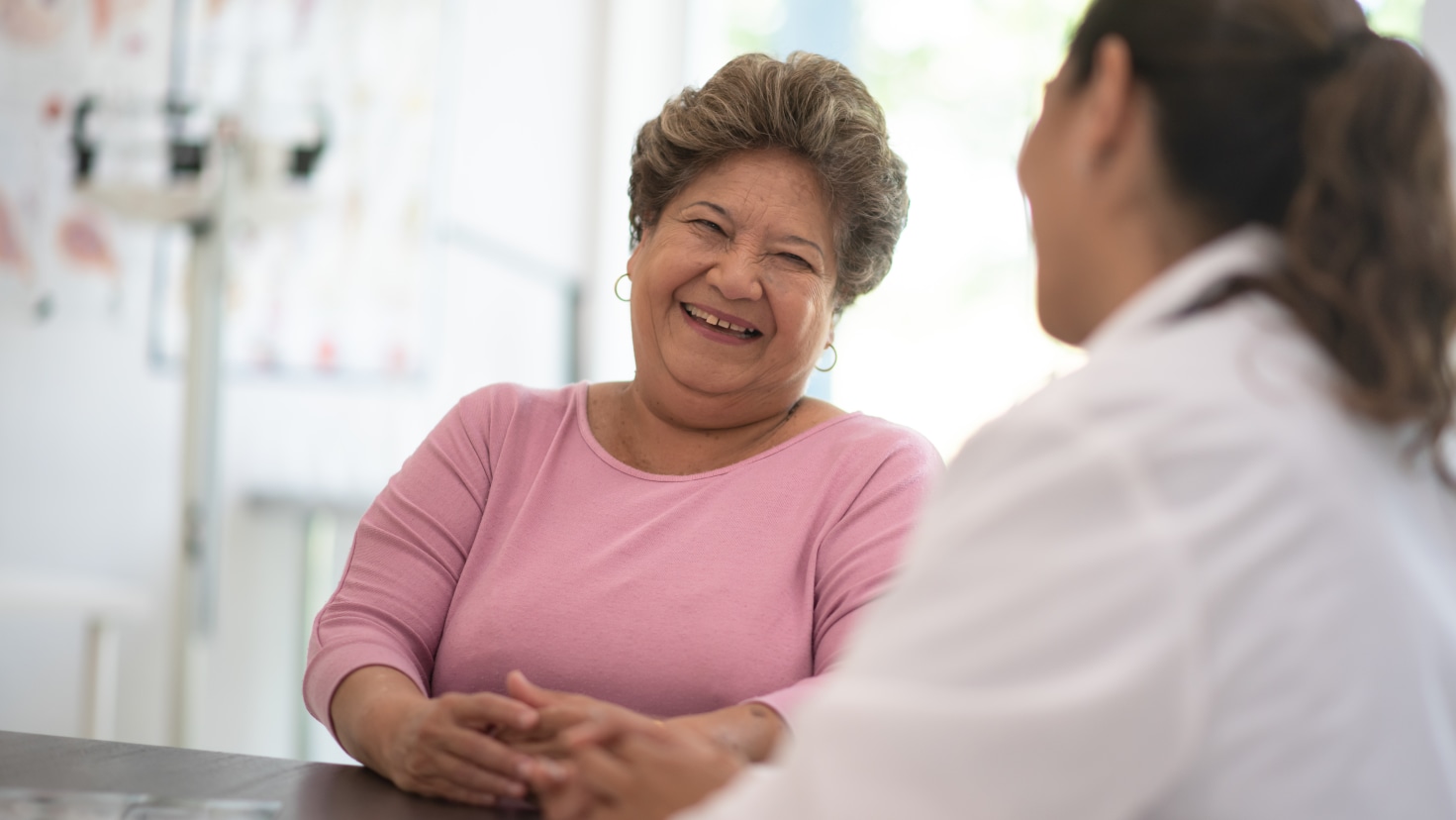 Middle-aged female patient talking with doctor.