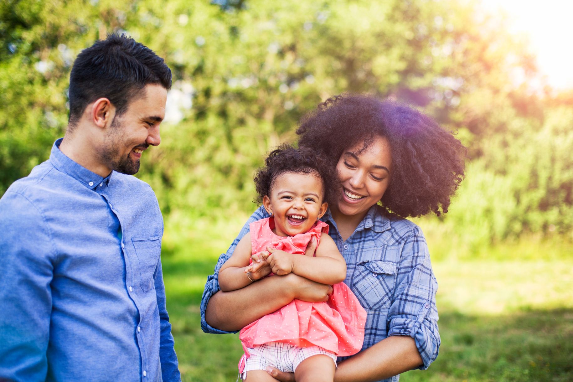 Family walking in field carrying young baby girl Family walking in field carrying young baby girl