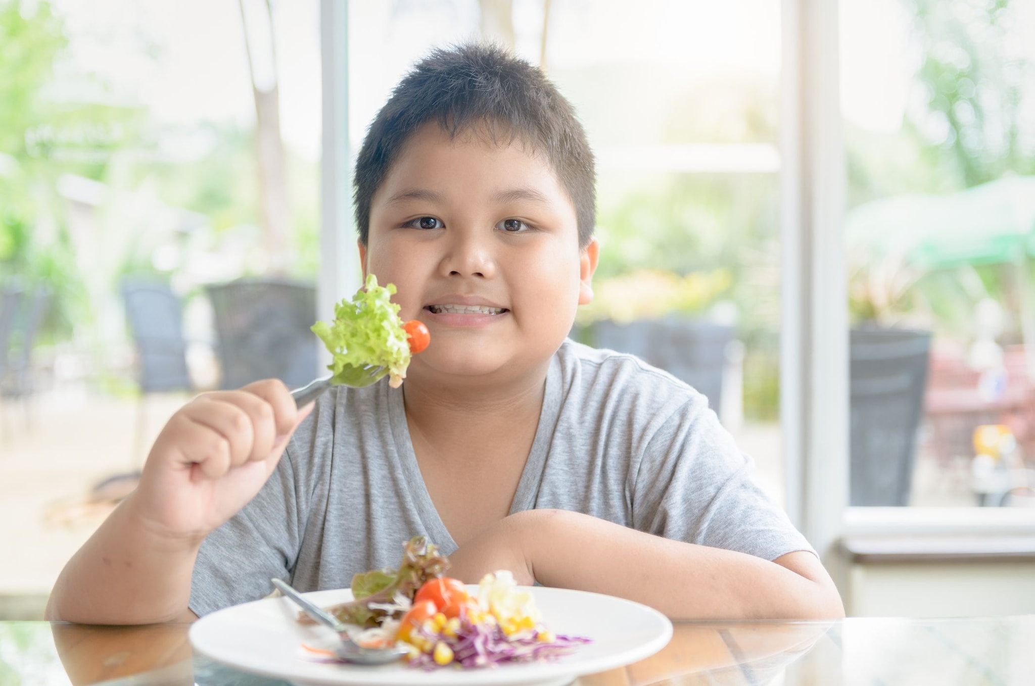 Young boy eating a salad