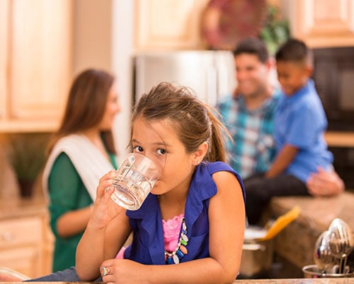 una niña bebiendo agua