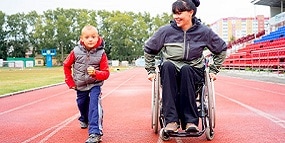 Woman in a wheelchair with a child getting ready to run