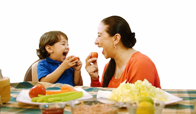 Madre e hijo divirtiéndose con verduras