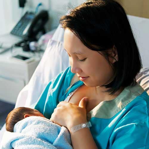 A mother breasting her child in a hospital room