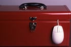 Photo of a toolbox with a computer mouse hanging out of it.