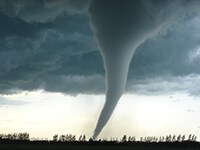 Large funnel tornado over country landscape