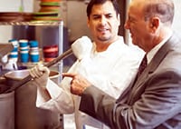 Photo of chef working with a manager in the kitchen.