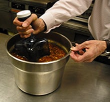 An ice wand being used to cool a pot of soup.