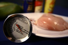 Photo of thermometer and raw chicken.