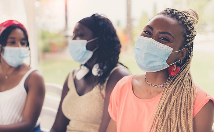 Close-up of three African American girls wearing surgical masks.
