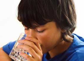 Image of boy drinking a glass of water.