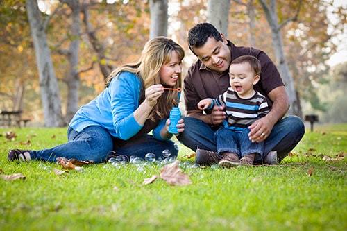 Mother, father and child playing in a park.