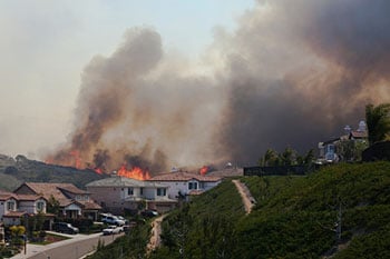 Wildfires burning near residential area.