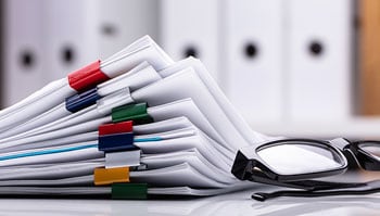 Stack of printed documents held together with binder clips