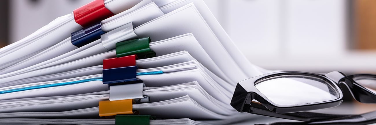 Stack of printed documents held together with binder clips.