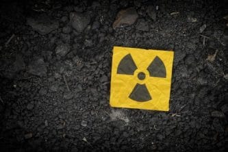 Radiation warning sign on soil background.