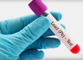 Gloved hands holding a vial showing label for Lead (Pb) Test