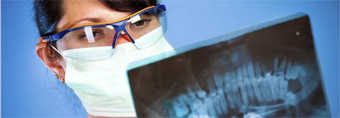 X-ray technician looking at a dental x-ray