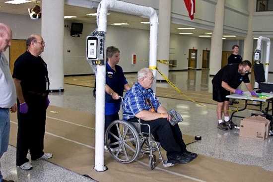 Un hombre con discapacidad pasando a través de una estación de lavado para la descontaminación