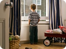 Young boy looking out over windowsill