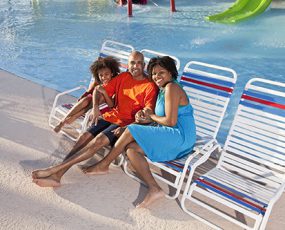 African American family on lounge chairs by pool