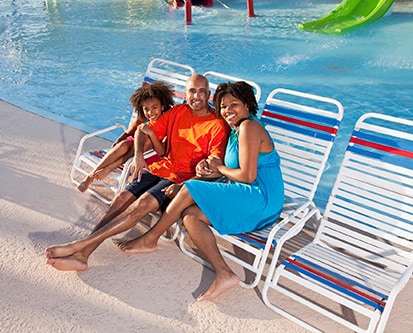 African American family on lounge chairs by pool