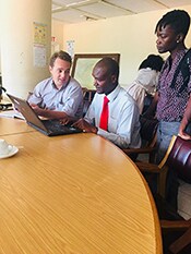 Drs. Bill Davis (EISO, WDPB) and Grace Appiah (Epidemiologist, WDPB), reviewing surveillance data with a colleague from the Ministry of Health.