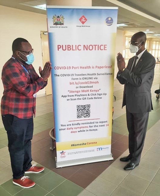 Charles Kamau of mHealth Kenya (left) provides a roll-up banner to Benjamin Murkomen (right)