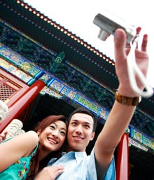 Couple taking a selfie in front of a building in Asia