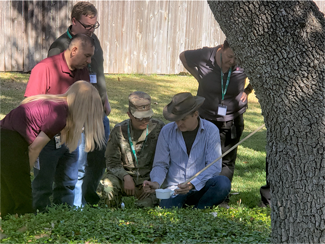 A group of people learning how to observe a mosquito dip.