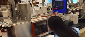 Imagen de una mujer observando la pantalla de un computador mientras trabaja en un laboratorio de los CDC