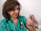 Image of a healthcare worker with her sleeve up as she receives a flu shot in her arm
