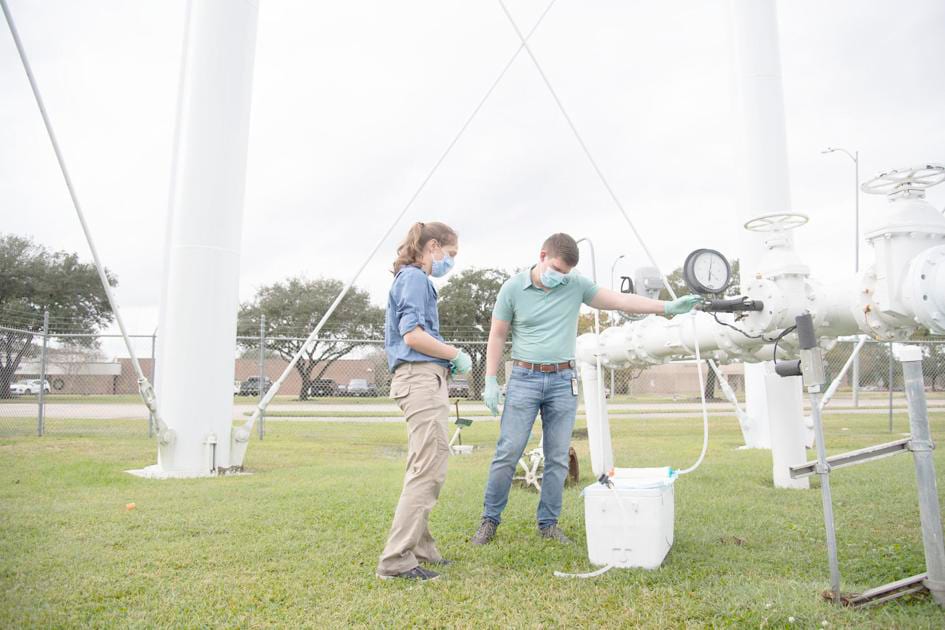 DFWED's Mia Mattioli and Travis Brown collect water from a water tower in Lake Jackson