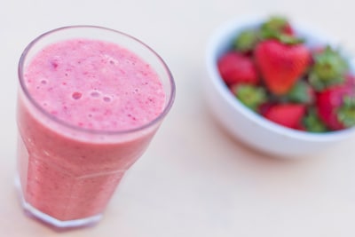 Image of a bowl of strawberries and a smoothie in a glass
