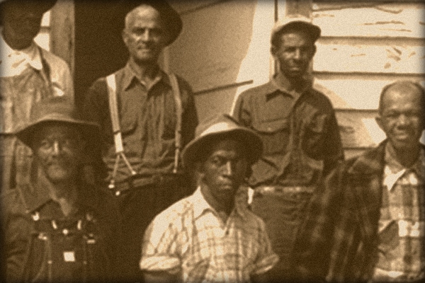 Sepia photograph of African American men standing outside of a building