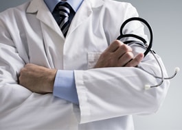 Photo of physician holding a stethoscope and arms folded