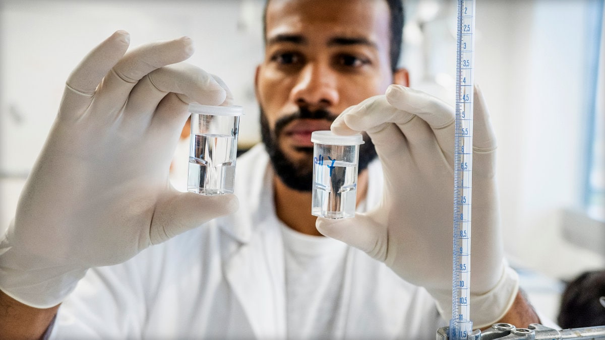 Photo of a microbiologist comparing vials of fluids