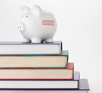 Stack of books with a piggy bank on top