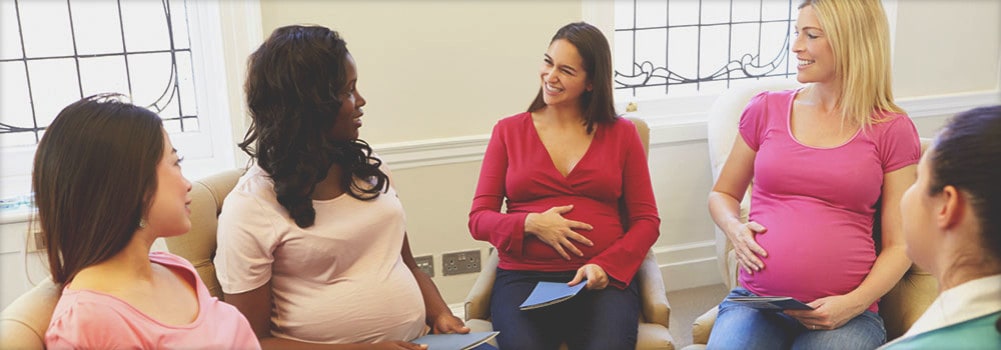 Group of Pregnant Women in Conversation in an Indoor Setting
