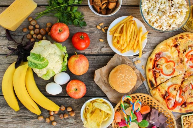 Fast food and healthy food on old wooden background