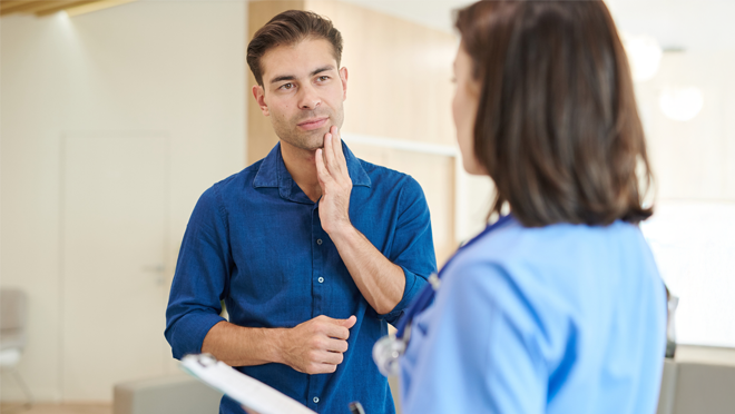 person with toothache meeting with medical professional