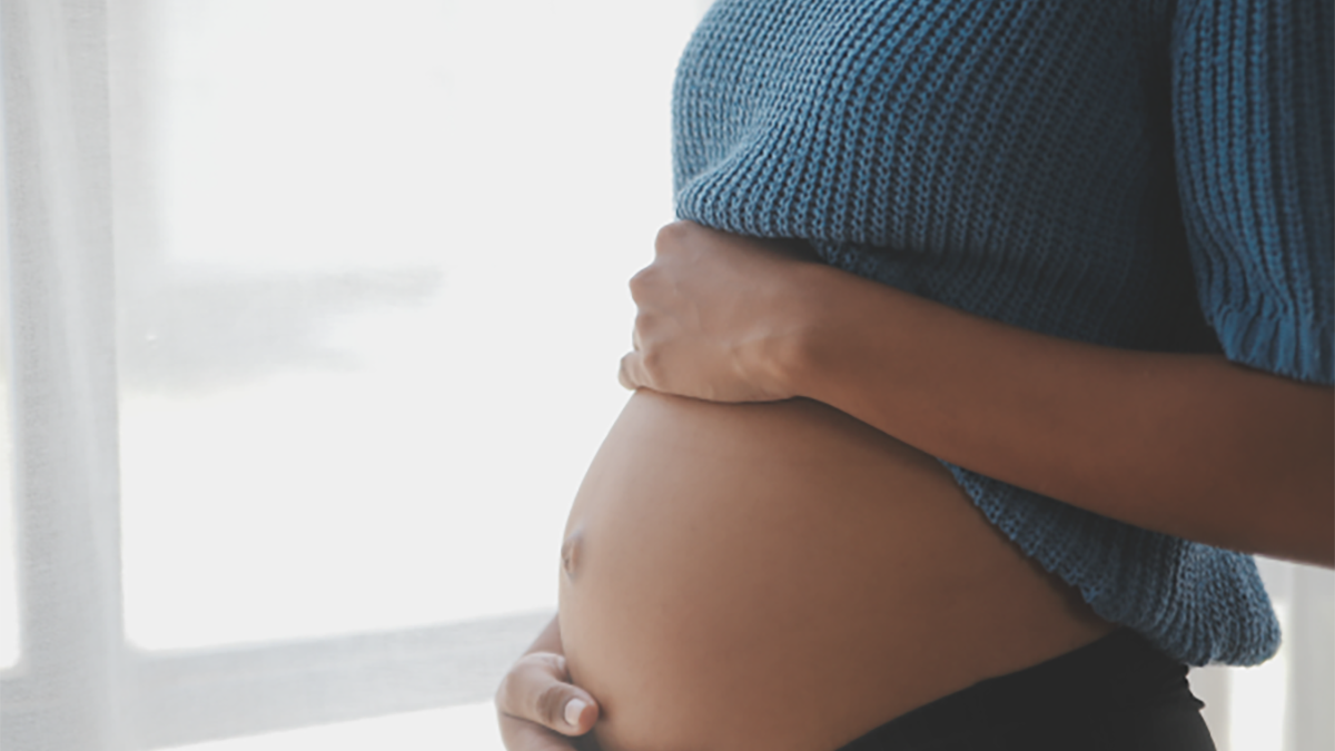 A pregnant woman holding her abdomen