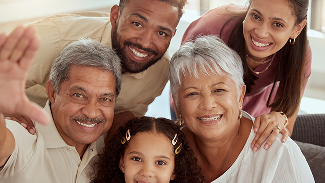 A multigenerational family smiling and posing for a picture.