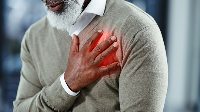 Man clutching his chest in pain seemingly having heart issues.