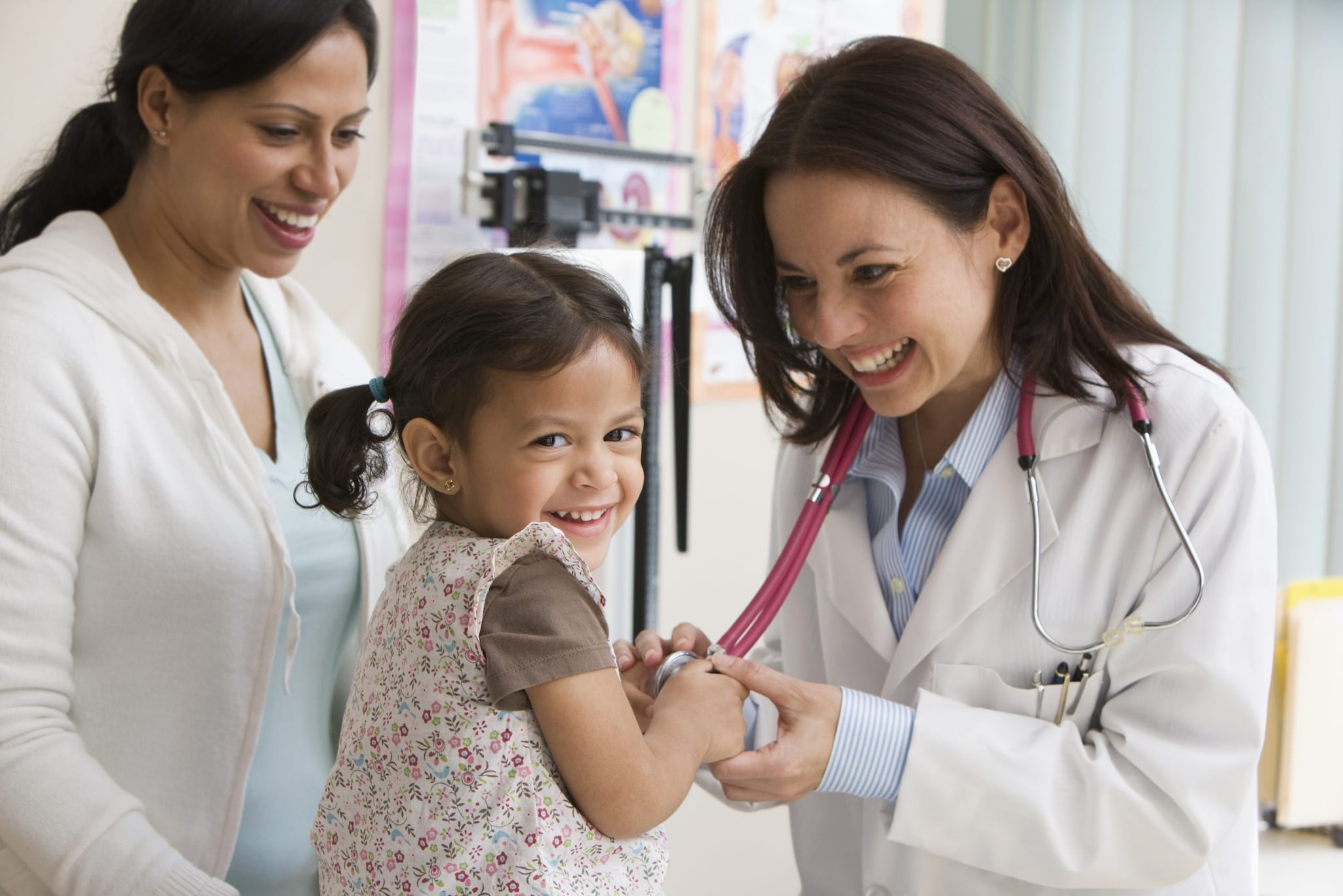 Toddler girl laughing while doctor examines